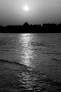 Deniz ve plaj kasabada ışınları günbatımı siyah ve beyaz