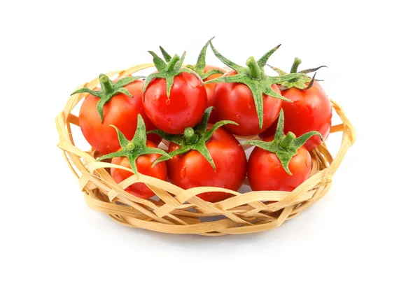 Pequeña cesta de mimbre de madera con tomates rojos aislados en blanco — Foto de Stock