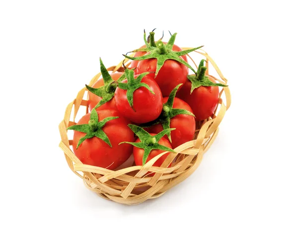 Pequeña cesta de mimbre de madera con tomates rojos aislados en blanco — Foto de Stock