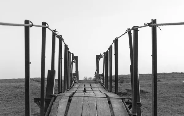 Brug van de spanning die zich uitstrekt in zonsondergang zwart-wit — Stockfoto