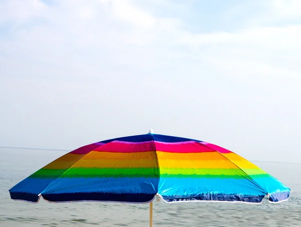 Paraguas de playa colorido sobre fondo de mar y cielo azul — Foto de Stock