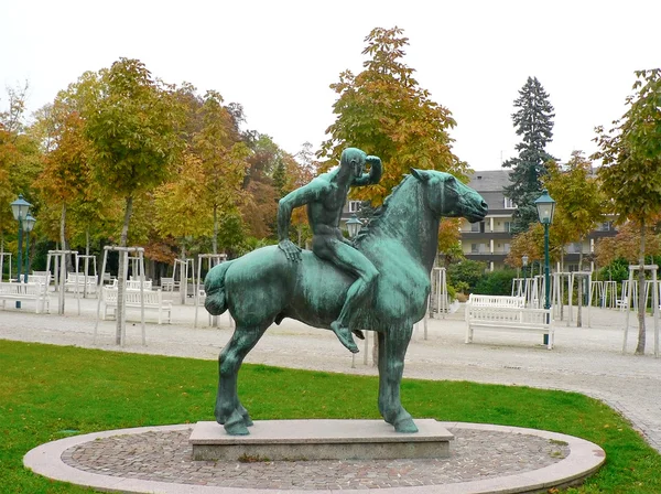 Bronze statue of horse rider looking forward in park — Stock Photo, Image