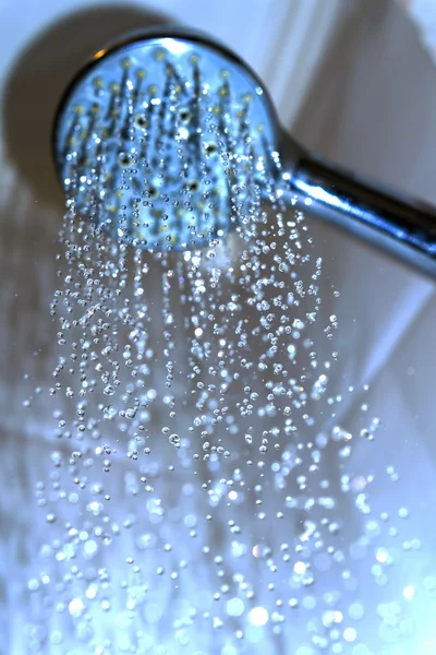 Waterdruppels close-up druipende uit de douche blauwe gefilterd — Stockfoto
