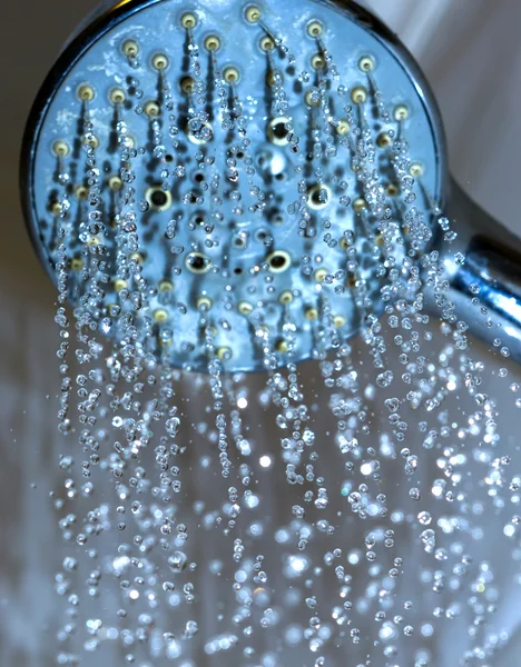 Waterdruppels close-up druipende uit de douche blauwe gefilterd — Stockfoto