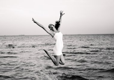 Mutlu esmer kız Denizin atlama. Retro fotoğraf siyah ve beyaz stilize