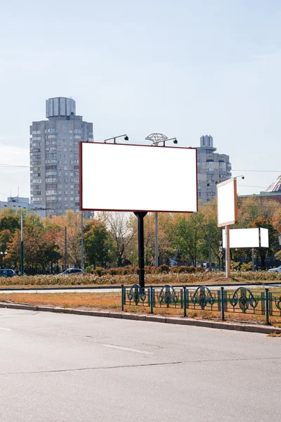 Blank white advertising banners near the road in autumn. Put your text or images inside