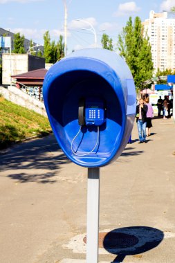 Şehir sokakta bulunan mavi genel telefon ile ayağı