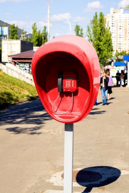Şehir sokakta bulunan kırmızı genel telefon ile ayağı