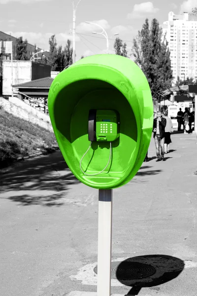 Pilar con el teléfono público verde fijado en la calle de la ciudad estilo blanco y negro — Foto de Stock