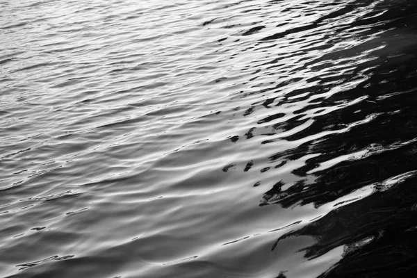 Água com reflexos solares textura de fundo preto e branco — Fotografia de Stock