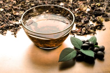 Filtre kurutulmuş pembe çay arka plan üzerinde sıcak natürmort fincan nane ile siyah çay yaprakları