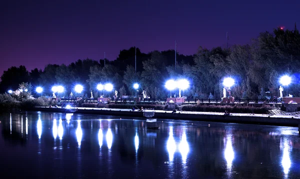 Вогні нічного міського торгового центру з відображенням на річці синього кольору — стокове фото