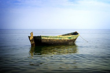 Boat at anchor in sea high contrasted with vignetting effect
