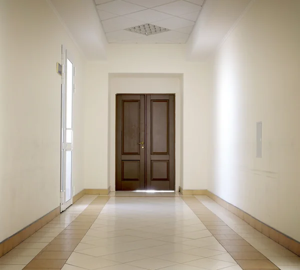 Corridoio bianco con pavimento in marmo e porta marrone in ospedale alto contrasto con effetto vignettatura — Foto Stock