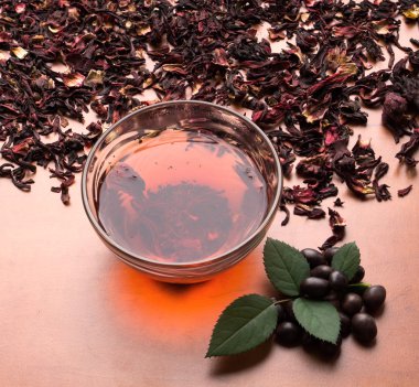 Siyah çay nane ile natürmort fincan kurutulmuş pembe çay arka plan üzerinde bırakır