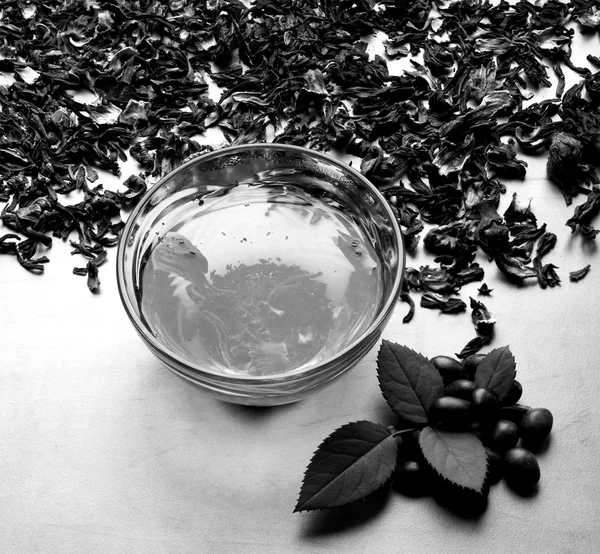Masih hidup secangkir teh hitam dengan daun mint pada kering karkade teh latar belakang hitam dan putih — Stok Foto