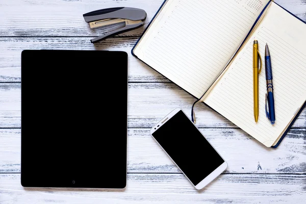 Lieu de travail moderne avec ordinateur portable, stylo doré et argenté, smartphone, bloc-notes et agrafeuse sur table vintage en bois blanc — Photo