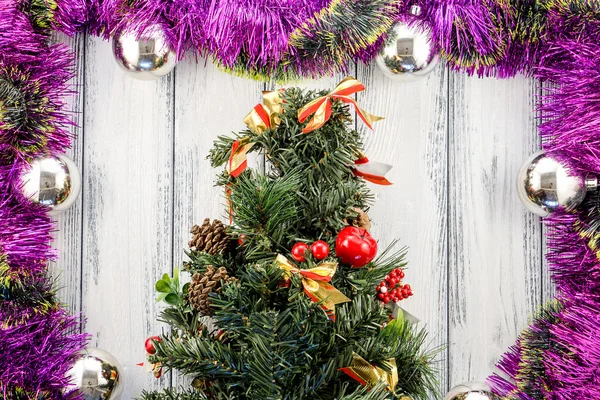 New year theme christmas tree with pink and green decoration and silver balls on white retro stylized wood background — Stock Fotó