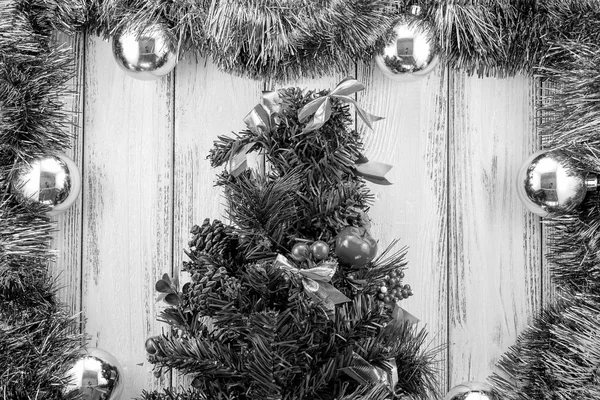 New year theme christmas tree with blue and green decoration and silver balls on white retro stylized wood background black and white — Zdjęcie stockowe