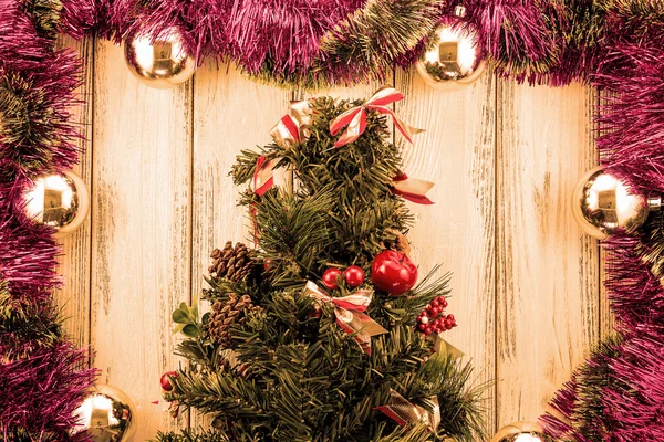 Neujahr Thema Weihnachtsbaum mit Dekoration und Kugeln auf weißem retro stilisiertem Holz Hintergrund orange gefiltert — Stockfoto