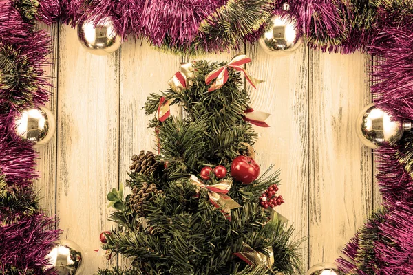 Neujahr Thema Weihnachtsbaum mit roter und grüner Dekoration und silbernen Kugeln auf weißem retro stilisiertem Holz Hintergrund warm gefiltert — Stockfoto