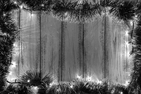 Tema de año nuevo: decoración del árbol de Navidad y guirnalda con luces sobre fondo de madera estilizada retro blanco y negro — Foto de Stock