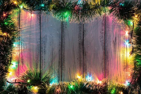 新しい年のテーマ: クリスマス ツリーの装飾と白いレトロな様式化された木材の背景の色のライトとガーランド — ストック写真