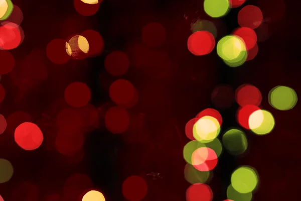 Fondo difuminado abstracto de decoraciones oscuras multicolores brillantes del árbol de Navidad en la noche caliente filtrado — Foto de Stock