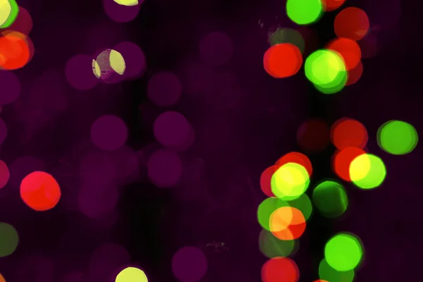 Fondo difuminado abstracto de decoraciones oscuras multicolores brillantes del árbol de Navidad por la noche — Foto de Stock