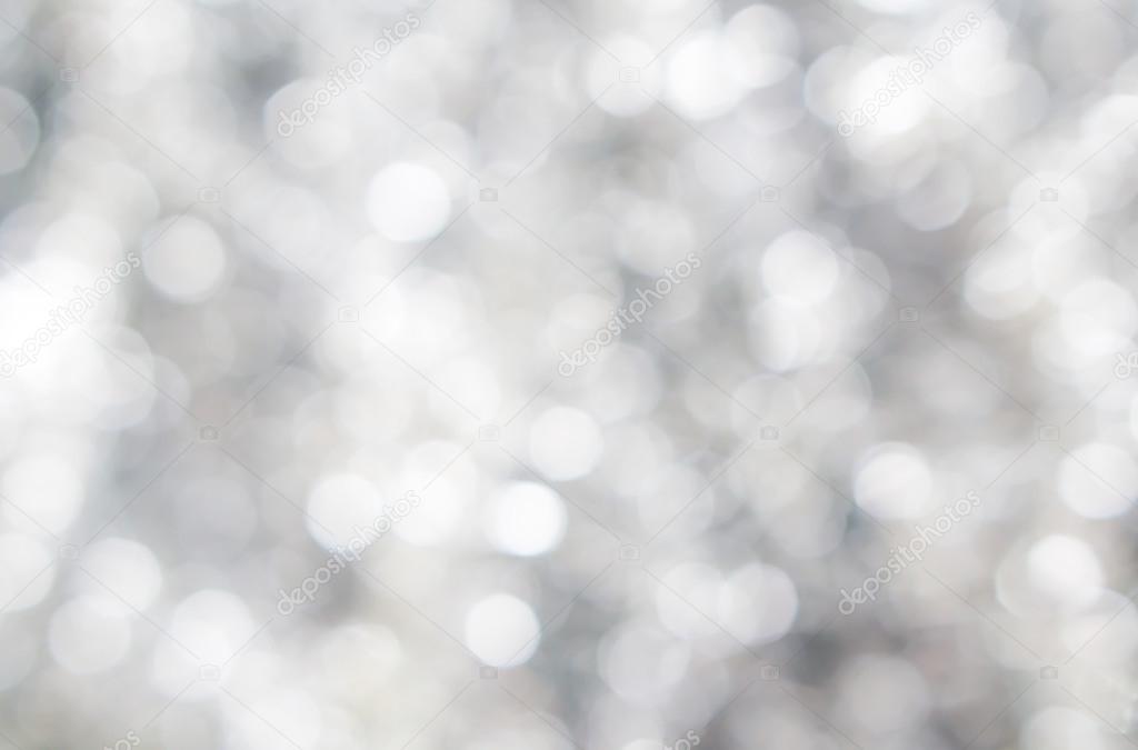 Abstract blured background of tender silver white shiny Christmas tree decorations