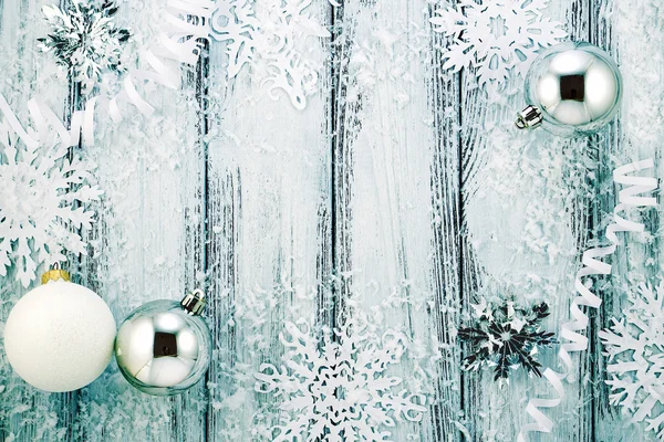 Yeni yıl tema: Noel ağacı beyaz ve gümüş süslemeleri, toplar, kar, kar taneleri, serpantin Menekşe aydınlatmalı beyaz retro Stilize ahşap zemin üzerinde — Stok fotoğraf