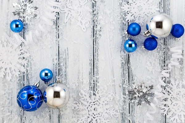 Nieuwjaar thema: kerstboom wit en zilver decoraties, blauwe ballen, sneeuw, sneeuwvlokken, serpentijn op witte retro gestileerde hout achtergrond — Stockfoto