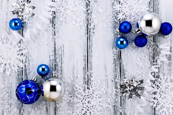 Το νέο έτος θέμα: λευκό και ασημί διακοσμήσεις χριστουγεννιάτικων δέντρων, μπλε μπάλες, χιόνι, νιφάδες χιονιού, σερπεντίνη ασπρόμαυρο ρετρό τυποποιημένο φόντο ξύλου σε αντίθεση — Φωτογραφία Αρχείου
