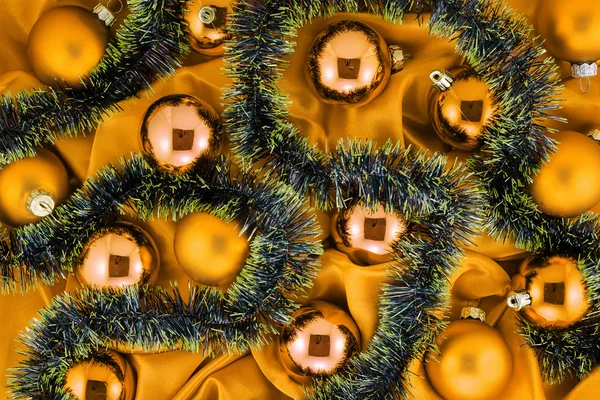 Fondo de bolas de árbol de Navidad de oro con decoraciones de oro y verde sobre tela de seda brillante oro —  Fotos de Stock