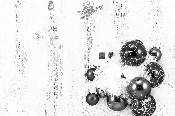 Tema de año nuevo: bolas de árbol de Navidad, nieve, copos de nieve, serpentina sobre fondo de madera estilizada retro blanco y negro — Foto de Stock