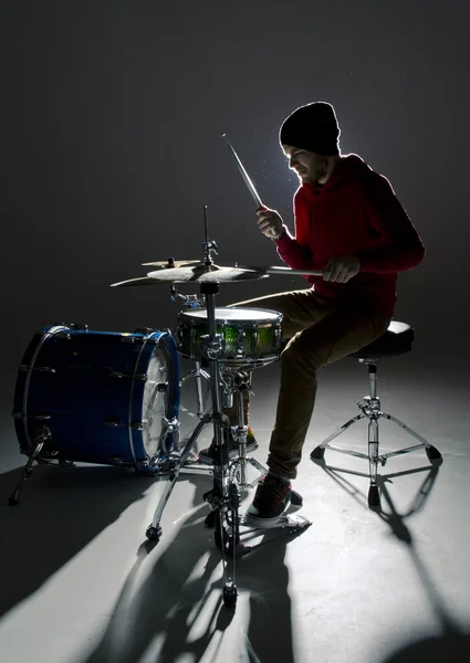 Joven baterista tocando en la contraluz Imagen de archivo