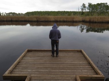 Kuzey Carolina 'nın harabelerinde sakin bir bataklığa bakan bir adam..