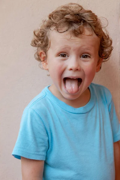 Charming Curly Haired Boy Blue Shirt Shows His Tongue Looks — Fotografia de Stock