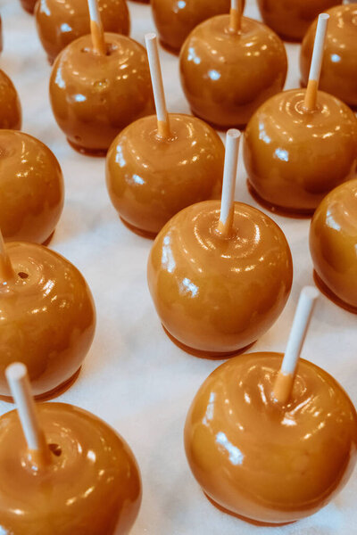 Gourmet caramel apple Pop at a Candy Store. Showcase with trays of apples dipped in sweet sous and chocolate. Homemade candy shop. Sweet food and desert concept. Fall Halloween  and Christmas treats. 