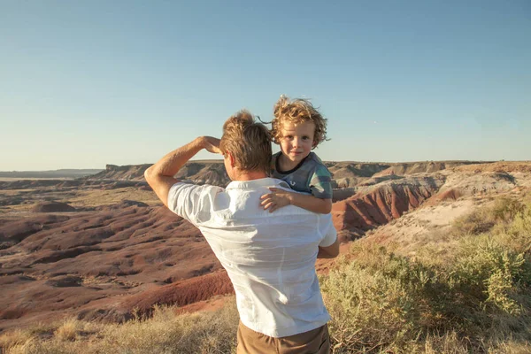 Happy family. Father and son hugging outdoors. Dad with his cute child walking outdoor Adorable curly boy hugging dad. Family Love concept. Summer vacation in American\'s nation parks Desert background