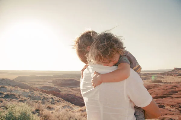 Happy family. Father and son hugging outdoors. Dad with his cute child walking outdoor Adorable curly boy hugging dad. Family Love concept. Summer vacation in American\'s nation parks Desert background