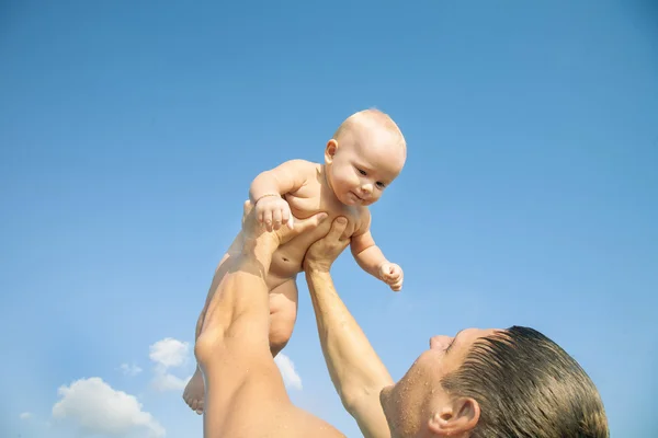 Отец, воспитывающий ребенка до небес — стоковое фото