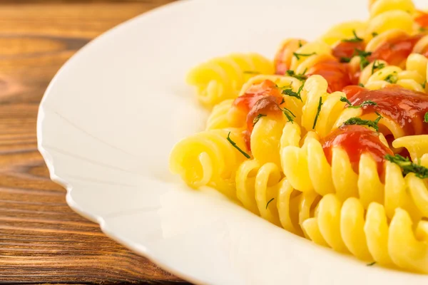 Italian pasta fusilli with tomato sauce in plate, close-up, selective focus — Stock fotografie