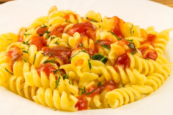 Italian pasta fusilli with tomato sauce in plate, close-up view — Zdjęcie stockowe
