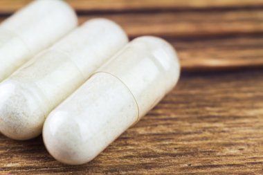 Food supplement pills, glucosamine capsules, macro image clipart