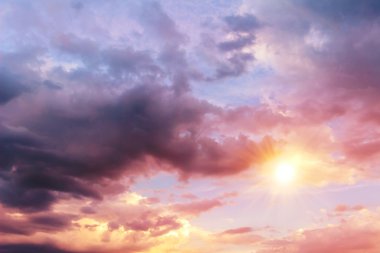 Güneş ve büyük koyu yağmur bulutları ile renkli gökyüzü arka plan.