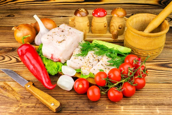 Trozos y rebanadas de manteca de cerdo fresca, productos frescos, verduras, verduras en la tabla de madera y cuchillo en la mesa . — Foto de Stock