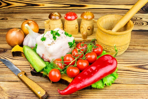Trozo de manteca de cerdo fresca, productos frescos, verduras, verduras en la tabla de madera y cuchillo en la mesa . — Foto de Stock