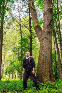 Yürüyüşçü, genç adam güzel ormanda yürüyor, yaşam tarzı, açık havada yaz yolculuğu kavramı.