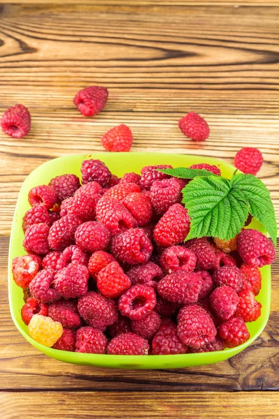 Bowl full of ripe raspberries on rustic wooden table. — Stock Photo, Image